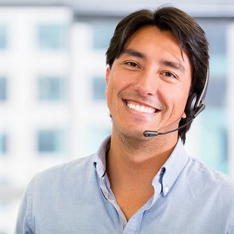 Un agente di vendita sorridente mentre indossa le cuffie e risponde a domande sull’applicazione CGM Eversense.